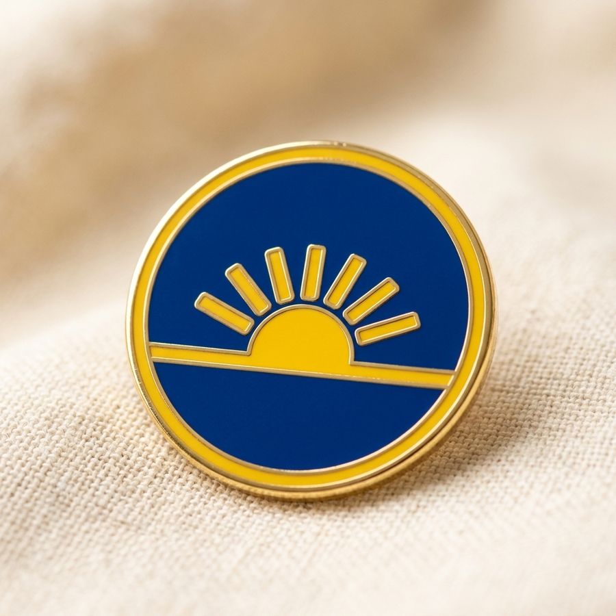 The Founder's Edition enamel pin — gold sun on cobalt